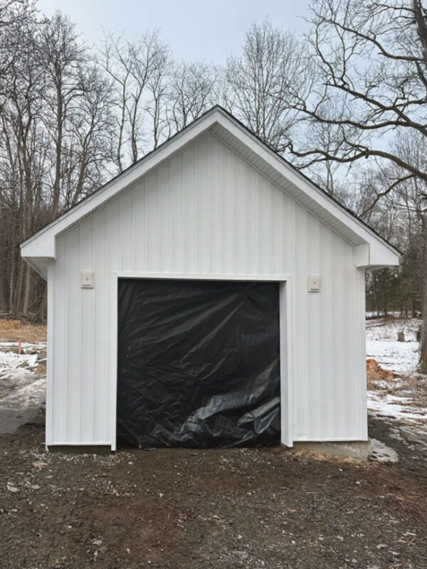 inal exterior view of the garage with completed siding, door, and trim