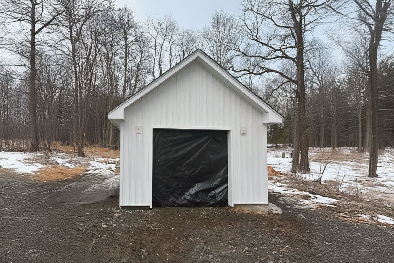 inal exterior view of the garage with completed siding, door, and trim
