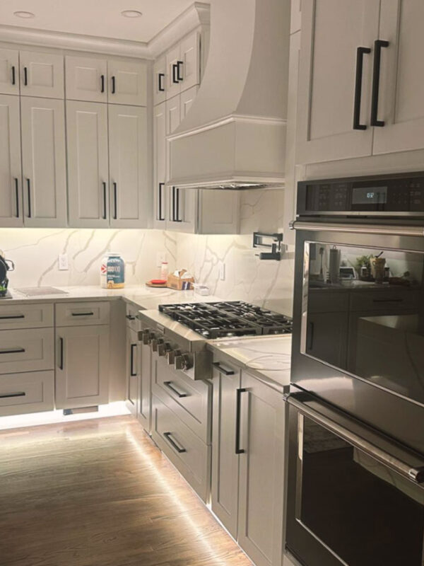 "Kitchen with light-colored cabinetry, a marble countertop, and sleek modern design